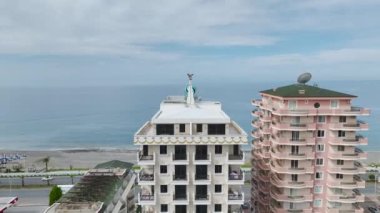 Akdeniz kıyısındaki lüks bir binanın 4K hava görüntüsünü yakalayın. Deniz manzaralı modern daireler..