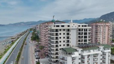 Akdeniz kıyısındaki lüks bir gökdelenin 4K insansız hava aracı görüntülerine bakın. Güzel deniz manzarası ve tasarım.