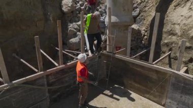 İnşaatçılar planlara, inşaat demirlerine ve temeli izole etmeye odaklanıyor. Hepsi de yukarıdan ele geçirilmiş..