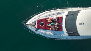 Beyaz bir yatta gün batımında eğlence ve rahatlama dolu bir yolculukta modellere katılın..