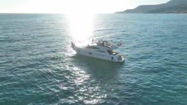 Güneş batarken beyaz bir yatta eğlenen neşeli mankenlere bakın..