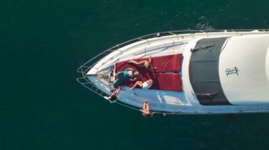 Mankenlerin beyaz bir yatta dinlendiği bir gün batımı sahnesine kaç..