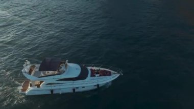 Okyanusu, gün batımında beyaz bir yatta dinlenen modellerle kutlayın..