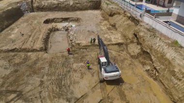İlk beton dökülürken ve inşaat alanında makineler çalışırken temel çalışmalarını izleyin..