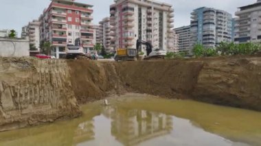 İnşaatın başlangıcında inşaatta çalışan temeli ve makineleri inceleyin..