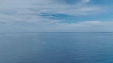 Deniz kıyısında lüks bir kompleksin üzerinden uçarak deniz ve dağların panoramik manzarasını sunuyorlar..