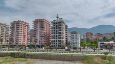 Deniz ve uzak dağlar tarafından boyanmış ufukları olan zarif sahil evlerine bakın..