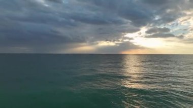 Akdeniz 'de bulutlu bir günbatımının sihrine tanık olun. Çarpıcı 4K hava görüntülerinde yakalandı..