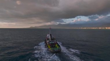 Gün batımında limana bir römorkun gelişine tanık olun, göz kamaştırıcı bir gökkuşağı ve gökkuşağı ile, 4K.