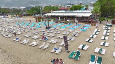 Denizde yağmurlu bir günün sakinliği, boş plaj sandalyeleri dizilmiş, 4K 'da çekiliyor..