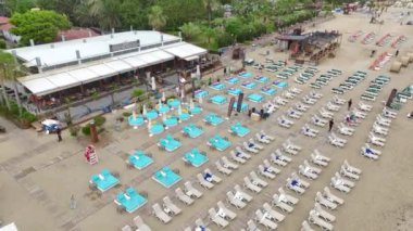 Yağmur, ıssız bir sahil sahnesini ıssız şezlonglar ve kafelerle yıkıyor, 4K 'da görülüyor..