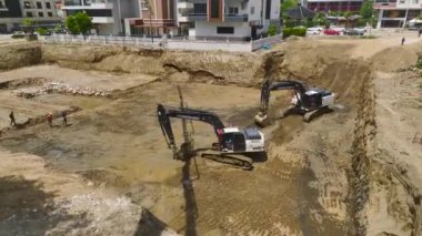 İnşaat alanındaki çukura ağır makineler beton dökerken yapı temelleri oluşturuluyor..