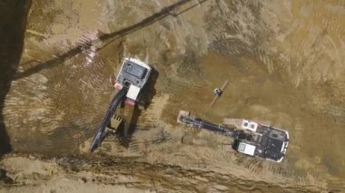 Bölgedeki ağır makineler tarafından çukura dökülen betonla başlayan yapıya bakın..