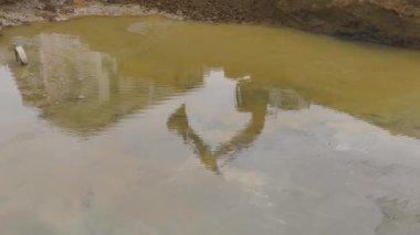 Bir çukura beton dökerek gelecek kule için temel oluşturan ağır ekipmanları gözlemleyin..