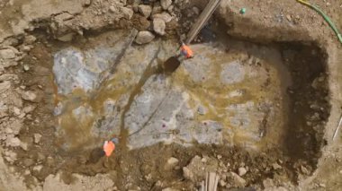 İşçilerin beton dökülmesi için çukuru hazırlayışını izleyin..