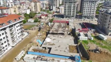 İşçiler demirleri bükerken ve beton dökerken binanın gelişimini izleyin..