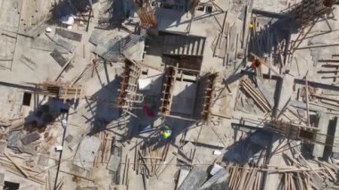 Demirleri büken ve temel için beton döken işçilere bakın.