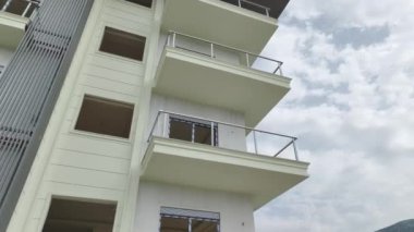 Gökten yakalanan pencere ve balkonları kurarak cepheyi tamamlayan işçilere bakın.