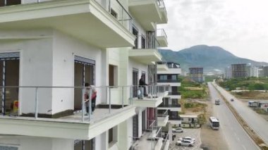 Son safhada balkonlar ve pencereler kurulurken tamamlanmak üzere olan evlere bakın.