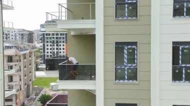 Ön cephe çalışmaları ve pencere kurulumlarıyla tamamlanmak üzere olan evleri izle.