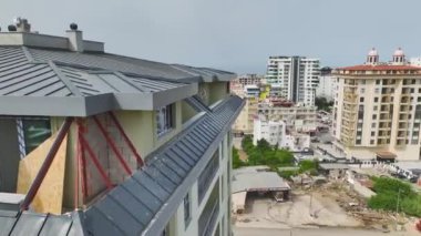 Pencere ve balkon kurulumları ile ön cephe işlerini bitiren işçileri gözlemle.
