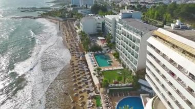 4K 'da yakalanan altın kum ve şemsiyeli güzel bir kumsalın keyfini çıkarın..