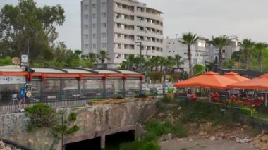Huzurlu Antalya şehrinde rıhtım boyunca koşan bir koşucu görüyorum..