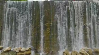 Dağın yamacından aşağı çağlayan bir şelale görüyorum. Yağmur yağıyor ve sis yükseliyor..