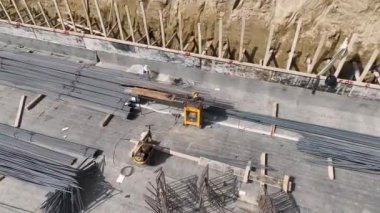 İnşaat alanında inşaat demirini hazırlayan ve şekillendiren işçilere bakın..