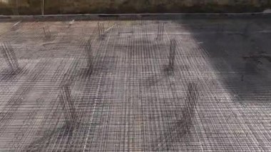 İnşaat işçilerinin inşaat demiri bükmelerini ve bir inşaat projesi için temel oluşturmalarını gözlemleyin..