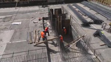 İnşaat alanında çalışanlara bakın. Yapısal çalışmalar için temel hazırlıyorlar ve demiri büküyorlar..