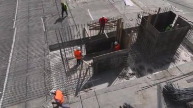 İnşaat işçilerinin inşaat demirine şekil vermelerini ve inşaat sahasının temelini atmalarını gözlemleyin..