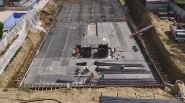 İnşaat alanında inşaat demirini büken ve temel çalışması için zemin hazırlayan işçilere bakın..