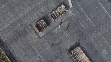 Güçlü bir temel oluşturmak için beton döken ve metali güçlendiren işçilere bakın.