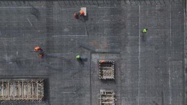 Güçlü bir yapı oluşturmak için beton döken ve metal büken işçileri izleyin..