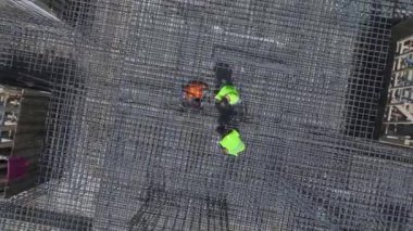 Yoğun bir inşaat alanında beton döküm ve metal yapı montajına dikkat edin.