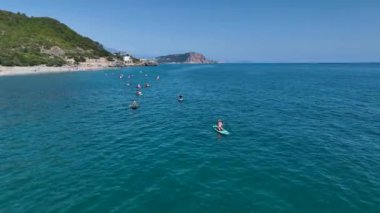 Alanya yakınlarındaki sakin açık denizde sörf yapan bir grup arkadaş yazın ilk gününün tadını çıkarıyorlar..