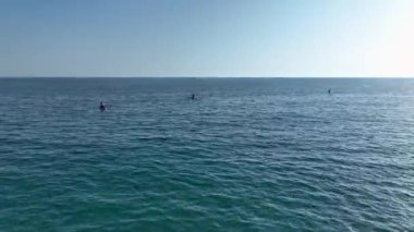 Yazın başlangıcını kutlamak için Akdeniz 'de güzel bir gölde sörf yapan bir grup görüyorum..