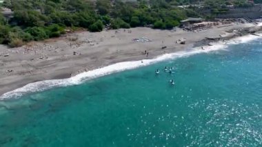 Yaz ayının ilk gününde turkuaz bir gölde insanların sörf yapmasını ve eğlenmesini izleyin..