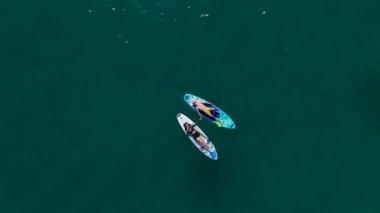 Akdeniz 'de düzenlenen SUP festivali sırasında bir grup raket kaykayı görün ve yaz güneşinin tadını çıkarın.