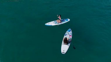 Mediterraneans göl gölündeki bir SUP festivalinde güneşli bir günün tadını çıkaran kürekçilere bakın..