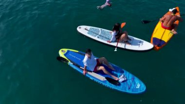 Bir SUP festivali sırasında Akdeniz 'de yazın ilk gününün tadını çıkaran raketçileri izleyin.