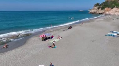 Sakin ve huzurlu bir körfezdeki bir pano festivalinde eğlenen bir grup görüyorum..