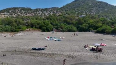 Canlı bir yaz festivali sırasında körfezde eğlenen bir grup kürekçi görün..