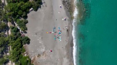 Eğlenceli bir yaz festivali sırasında bir körfezin açık denizinde dinlenen ve ata binen bir grup kürekçi görün..