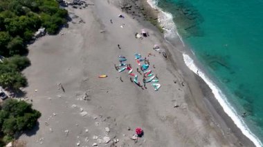 İnsanlar kürek çekerken ve dinlenirken bir koyun huzurlu sularında bir SUP festivali izleyin..