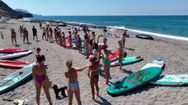 Sakin bir koyda, insanların açık denizde at sürdüğü ve rahatladığı eğlence dolu bir raket festivali seyredin..