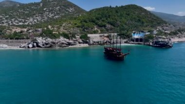 Kürekçilerin huzurlu bir körfezdeki yaz festivalinde eğlenmelerini izlemek, güneşin tadını çıkarmak..
