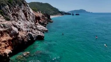 Yaz festivalinin tadını çıkaran arkadaşlarınızı yazın ilk günü sakin bir körfezde sörf yaparken izleyin..