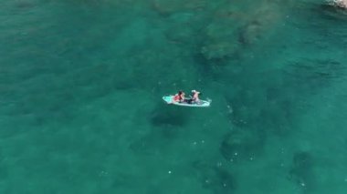 Kürek çeken insanların manzarasının tadını çıkarın ve yazın ilk gününü sakin bir körfezde kutlayın..